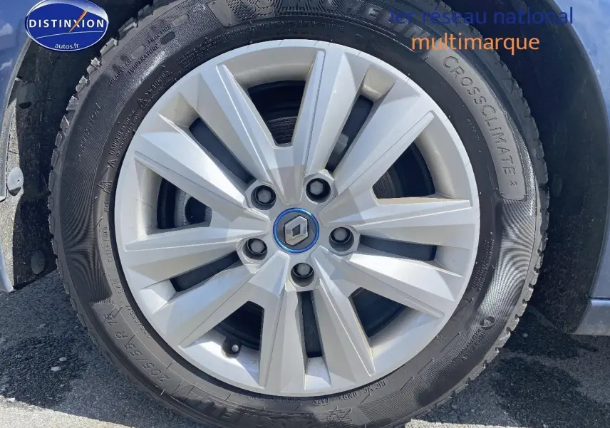 Gros plan sur la jante alu argentée avec logo Renault au centre d'une Renault Mégane IV Estate bleu.