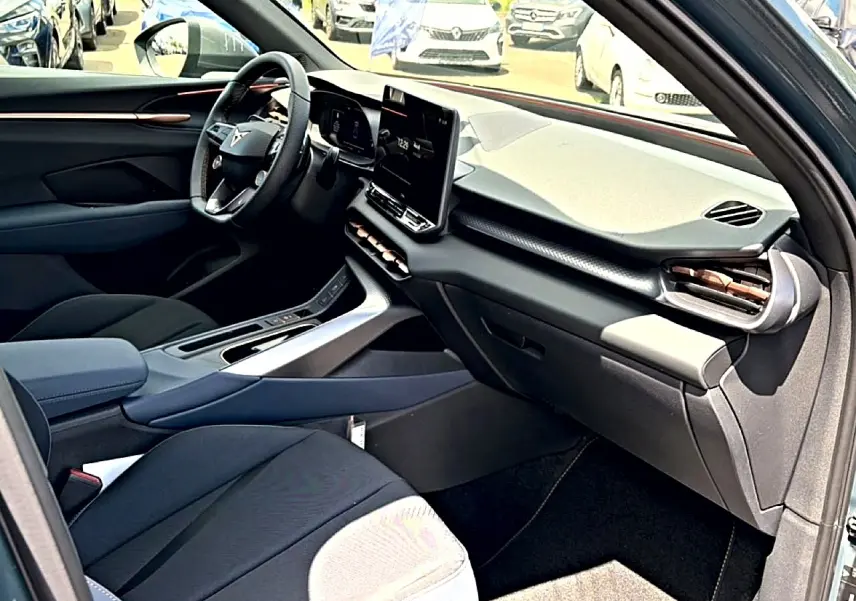 Intérieur de la CUPRA TERRAMAR bleu fjord, vue côté passager avant avec tableau de bord moderne et écran tactile vertical.