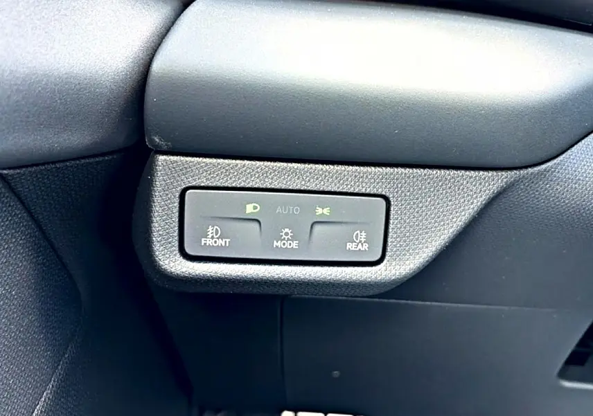 Détail du tableau de bord noir du CUPRA TERRAMAR 2026 montrant les commandes d’éclairage automatiques.