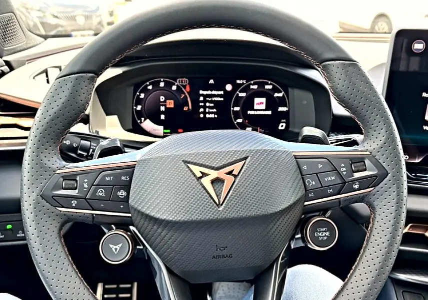 Gros plan sur le volant cuir perforé du CUPRA TERRAMAR 2026 avec logo cuivré et commandes multifonctions.