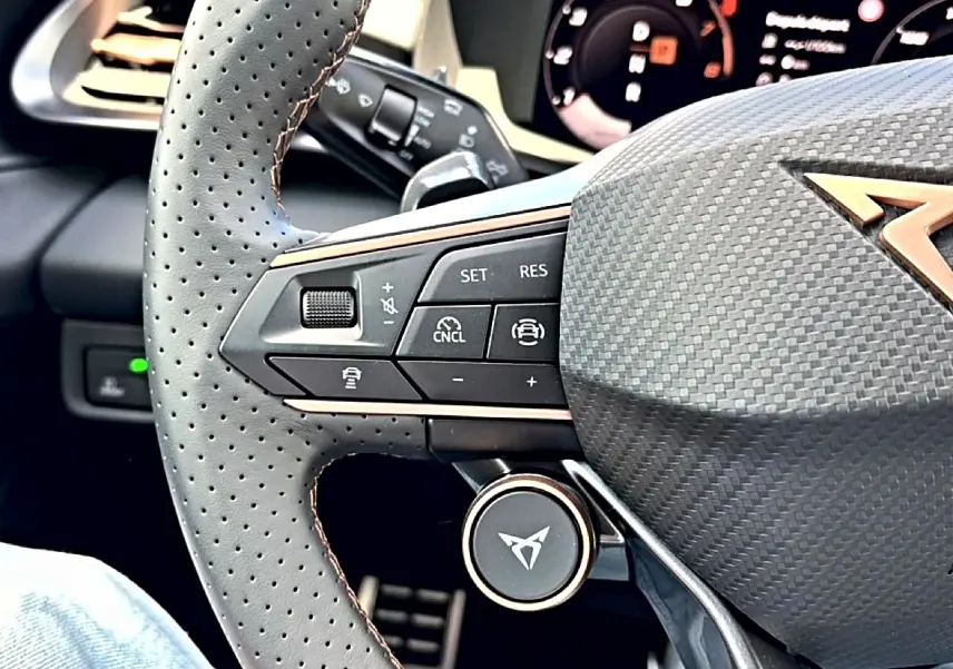 Gros plan sur le volant cuir perforé avec commandes multifonctions et logo CUPRA bronze du Terramar Bleu Fjord 2026.