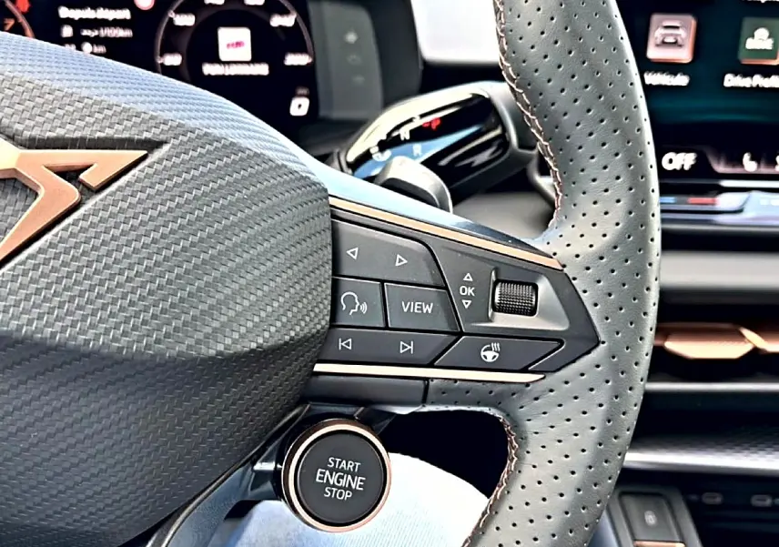 Gros plan sur le volant cuir perforé et les commandes multifonctions du CUPRA Terramar 2026, intérieur noir et cuivre.