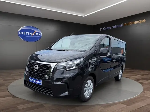 Nissan Primastar noir en 3/4 avant droit, avec calandre chromée et feux LED, présenté en showroom Distinxion.