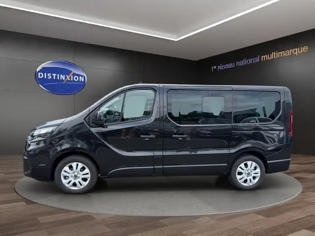 Vue de profil côté gauche d'un Nissan Primastar noir 2025 avec vitres teintées et jantes argentées en showroom.
