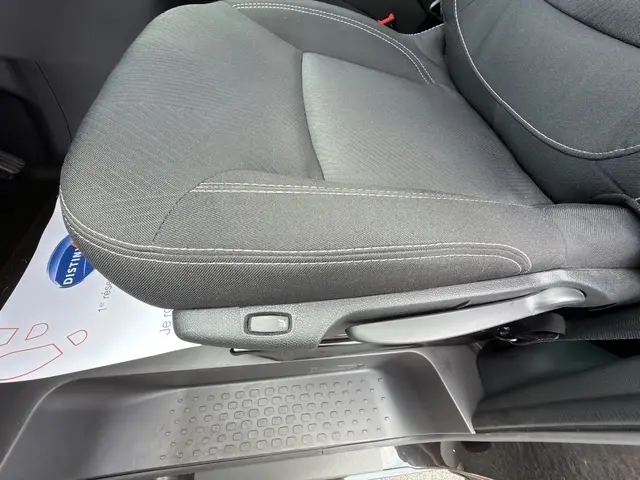 Gros plan sur le siège avant droit noir du Nissan Primastar 2025 avec réglage manuel et tapis de sol visible.