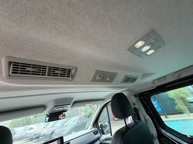 Vue intérieure du toit et des aérateurs arrière du Nissan Primastar noir, avec éclairage et commandes de climatisation visibles.