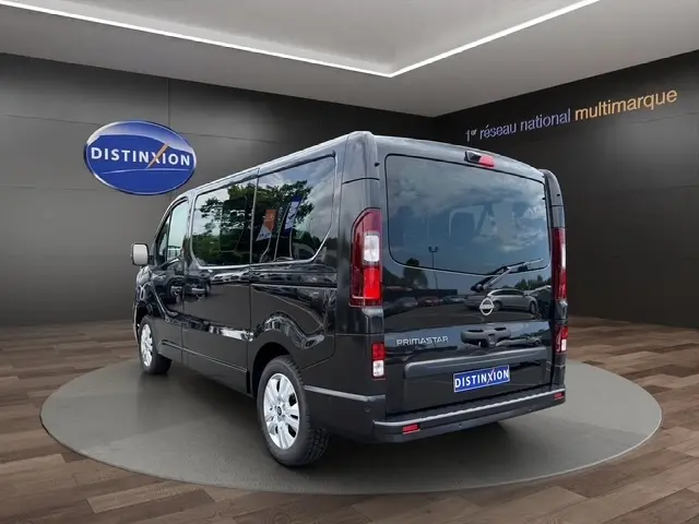 Vue 3/4 arrière droite du Nissan Primastar noir 2025 avec vitres teintées et feux arrière verticaux LED.