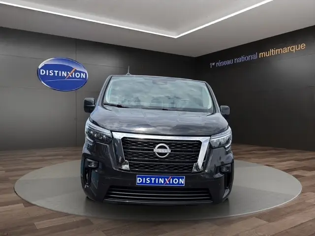Vue de face d'un Nissan Primastar noir avec calandre chromée et phares LED dans un showroom Distinxion.
