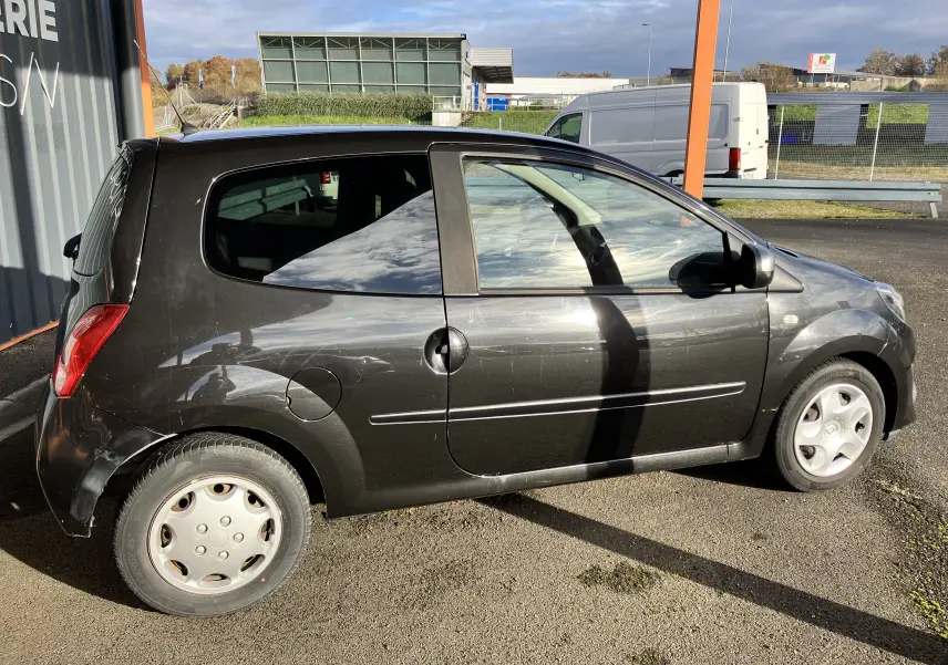 Profil côté gauche d'une Renault Twingo II noire de 2011, compacte avec une porte unique sur ce côté.