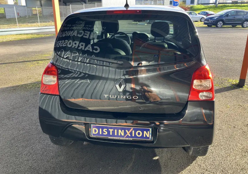 Vue arrière d'une Renault Twingo II noire de 2011 avec logo et plaque d'immatriculation Distinxion visible.