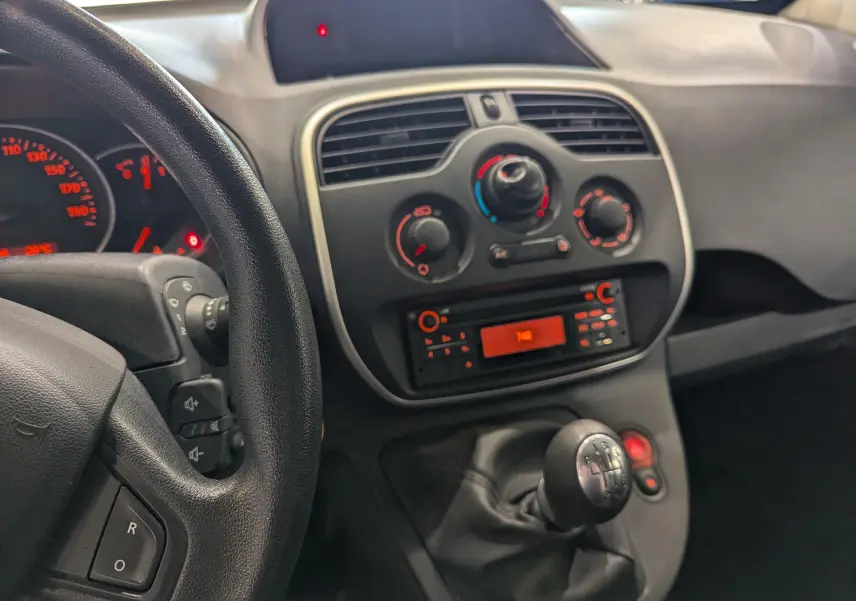 Vue intérieure du tableau de bord et levier de vitesse manuel du Renault Kangoo Express 2021, ambiance sobre et fonctionnelle.
