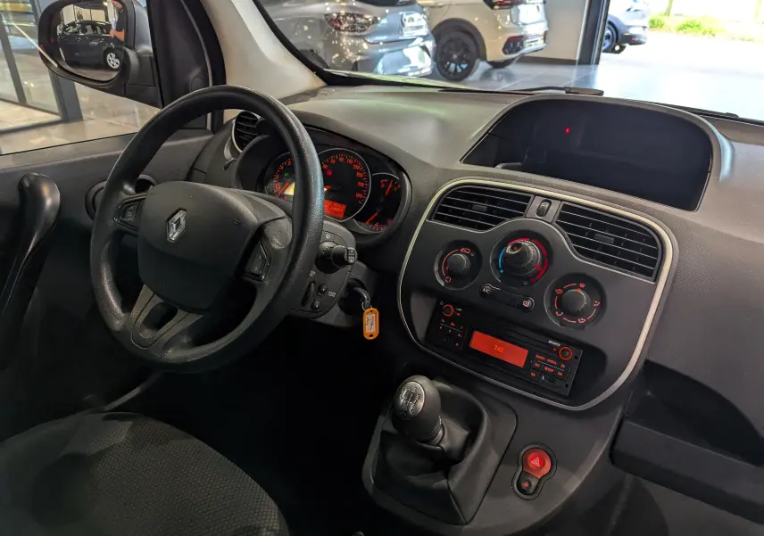 Vue intérieure côté conducteur du tableau de bord et volant noir du Renault Kangoo Express blanc 2021.