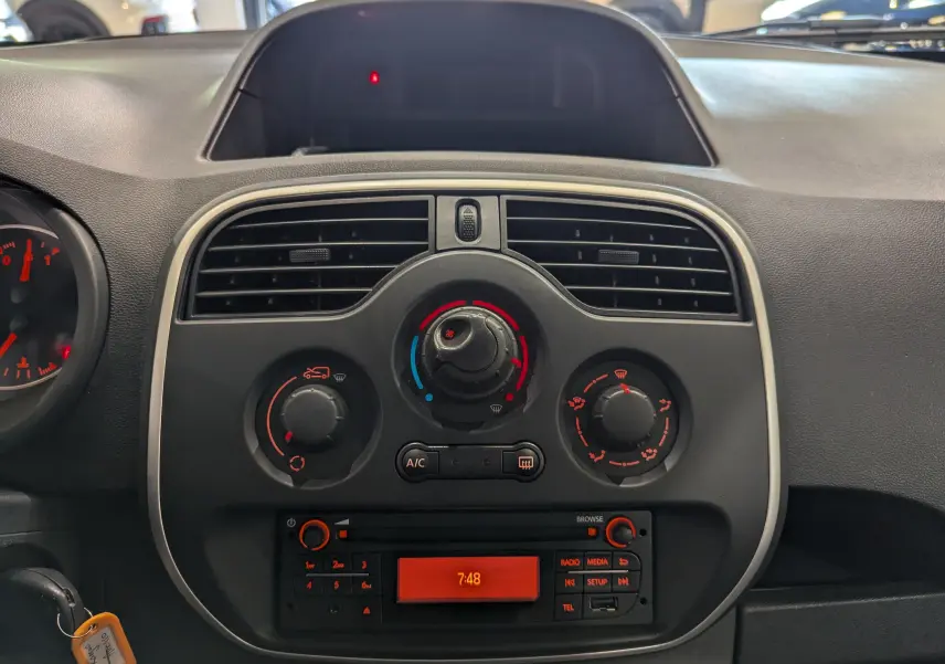 Vue rapprochée du tableau de bord du Renault Kangoo Express 2021, avec commandes de climatisation et radio intégrée.