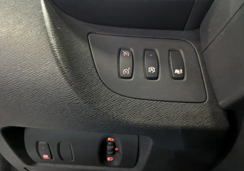 Gros plan sur les commandes de régulateur de vitesse, arrêt automatique et aide au démarrage en côte du Renault Kangoo Express blanc.