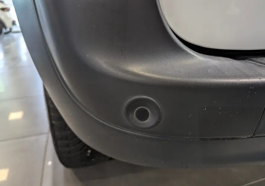 Gros plan sur le capteur de stationnement arrière droit du Renault Kangoo Express blanc minéral 2021.
