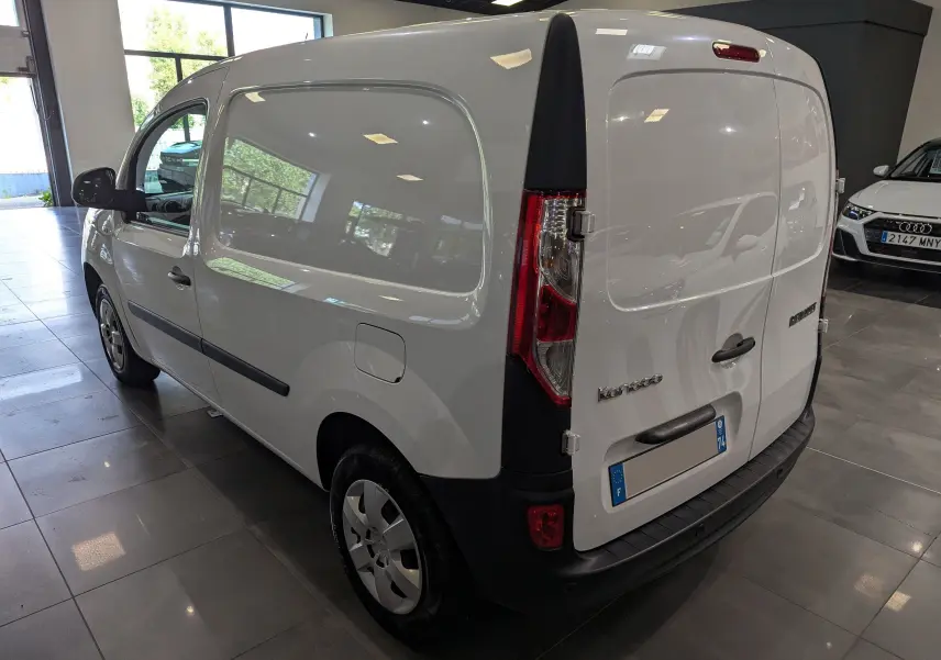 Vue 3/4 arrière droite d'un Renault Kangoo Express blanc minéral, fourgon utilitaire en showroom avec feux arrière verticaux.