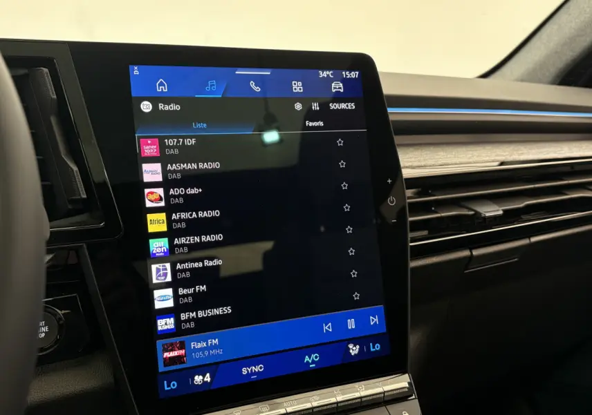 Écran tactile central 12 pouces du tableau de bord du Renault Austral blanc, avec commandes climatisation visibles.