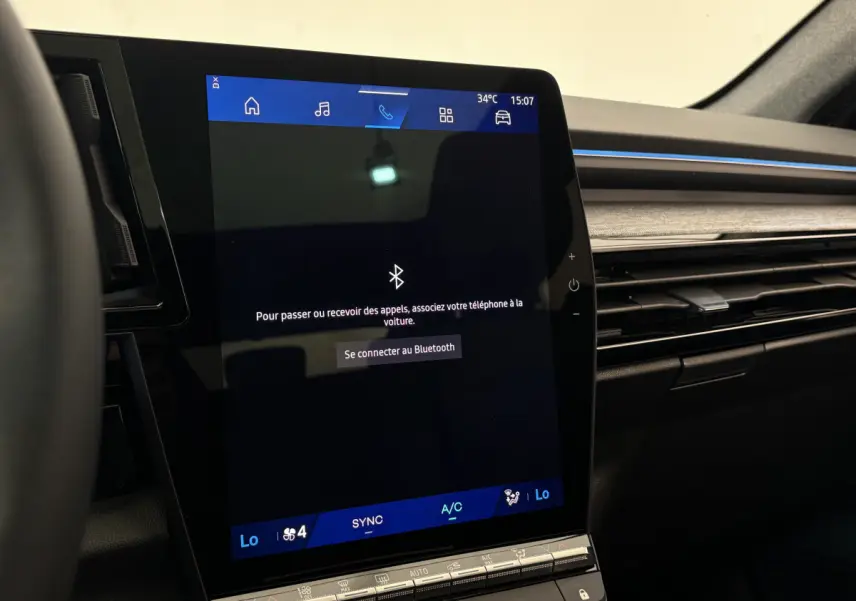 Écran tactile central affichant la connexion Bluetooth dans l'habitacle noir du Renault Austral blanc 2025.