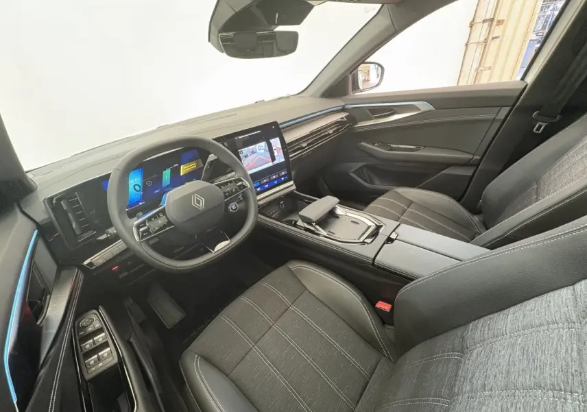 Intérieur du Renault Austral 2025 vu côté conducteur, avec tableau de bord numérique et sièges tissu gris.