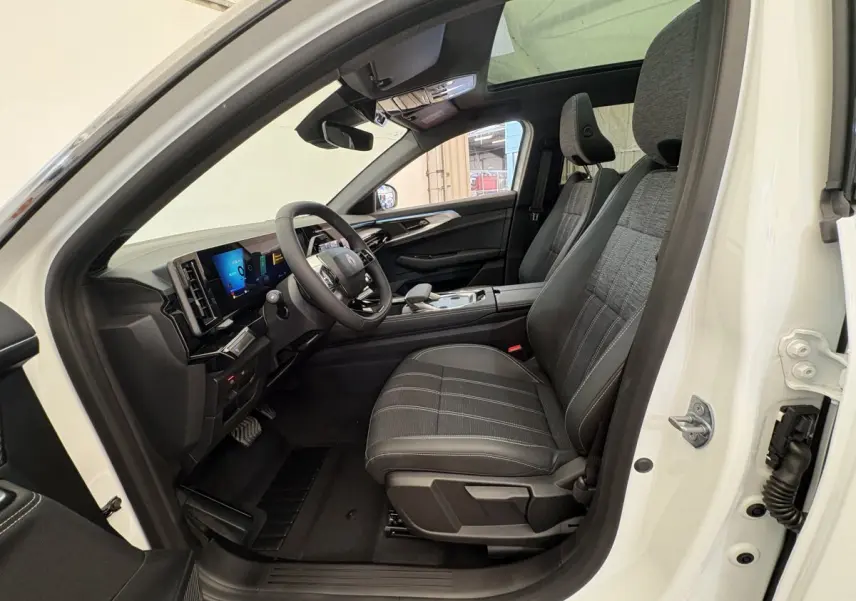 Intérieur côté conducteur du Renault Austral blanc 2025, montrant sièges noirs et tableau de bord avec écran tactile.