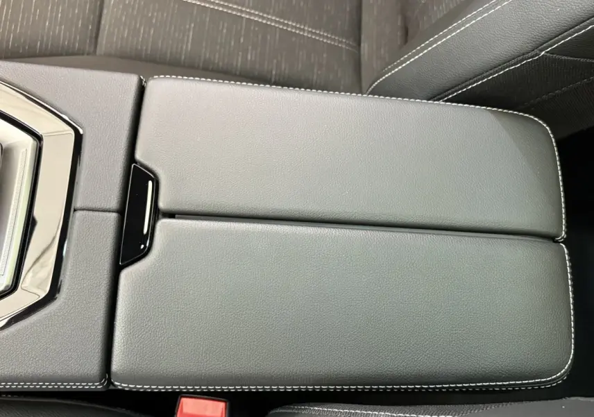 Vue rapprochée du couvercle de la console centrale en cuir noir avec surpiqûres blanches du Renault Austral 2025.