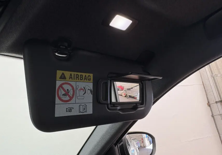 Miroir de courtoisie ouvert sur pare-soleil noir à l'intérieur d'un Renault Austral 2025, vue côté conducteur.