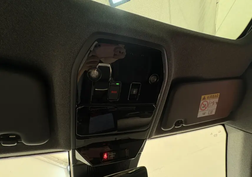 Vue en plongée du plafonnier noir brillant avec bouton SOS et avertissement airbag du Renault Austral blanc 2025.