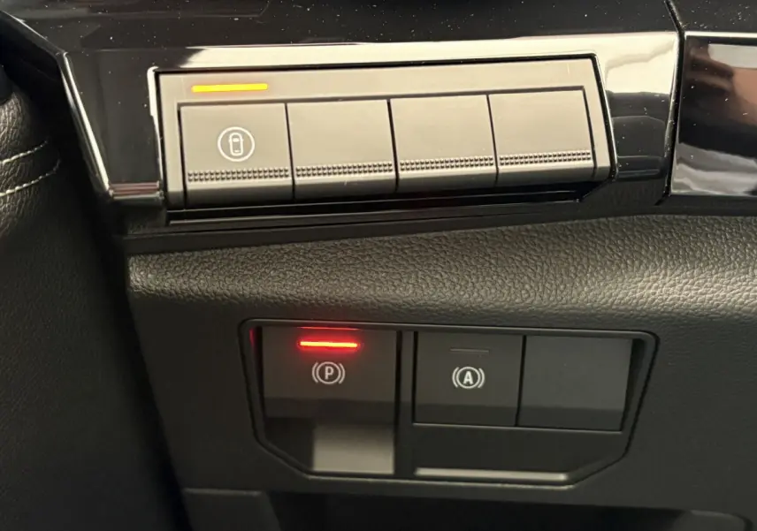 Gros plan sur les commandes de frein à main électrique et arrêt auto du Renault Austral 2025, intérieur noir.