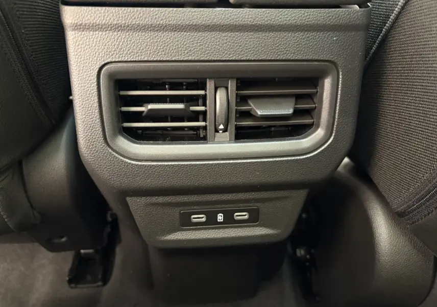 Prise USB double et bouche d'aération arrière centrale noire dans l'habitacle du Renault Austral blanc 2025.