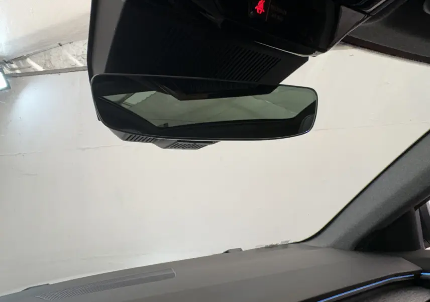 Vue intérieure du rétroviseur central et tableau de bord noir du Renault Austral blanc 2025 hybride.