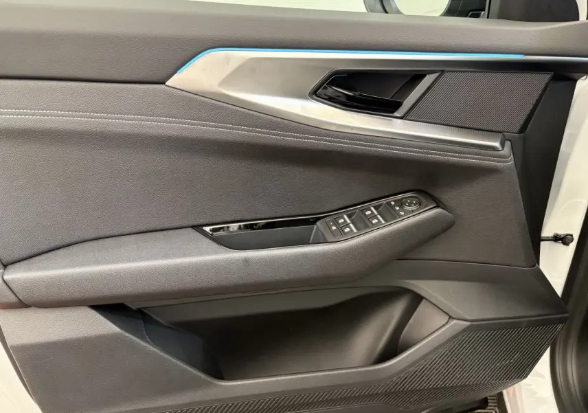 Panneau de porte côté gauche du Renault Austral blanc 2025, avec commandes de vitres et insert décoratif bleu.