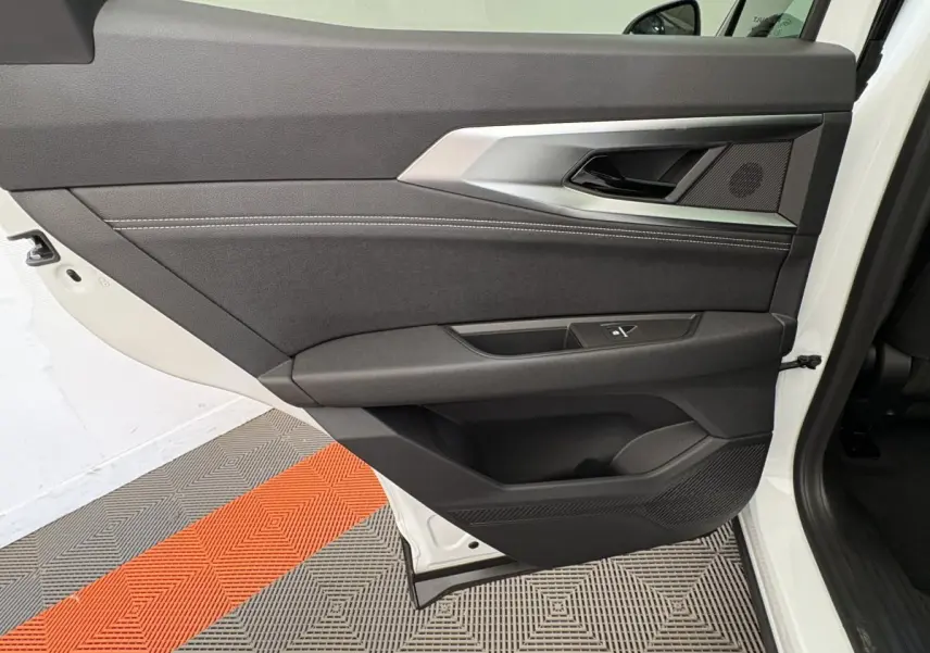 Gros plan sur la porte arrière gauche blanche du Renault Austral 2025, avec garniture noire et détails métalliques.