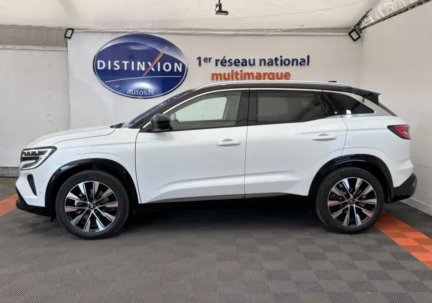 Profil côté gauche d'un Renault Austral blanc 2025 avec jantes alliage et toit noir en showroom.