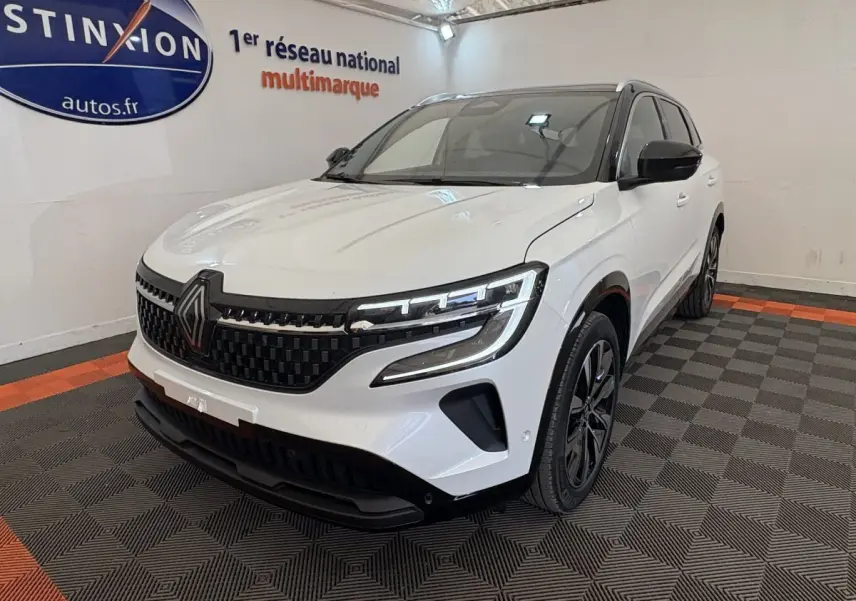 Renault Austral blanc en 3/4 avant droit, avec calandre noire à damier et phares LED distinctifs.