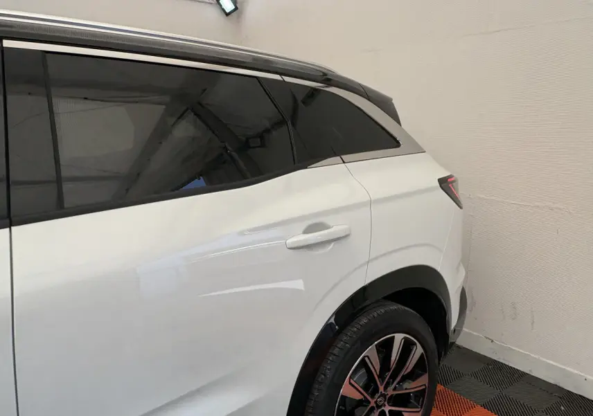 Vue latérale arrière droite du Renault Austral blanc avec vitres teintées et jantes alliage distinctives.