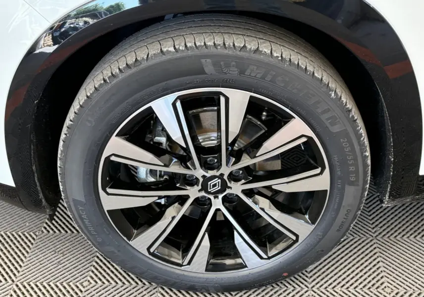 Gros plan sur la roue avant droite blanche du Renault Austral 2025 avec jante alliage noire et argentée design moderne.