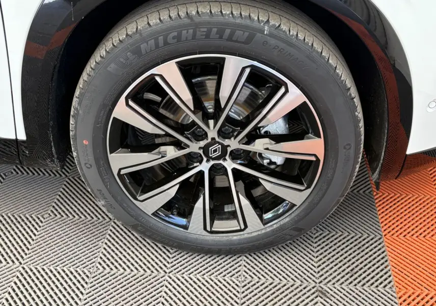 Gros plan sur la roue avant droite blanche du Renault Austral 2025 avec jante alliage noir et argent Michelin e-Primacy.