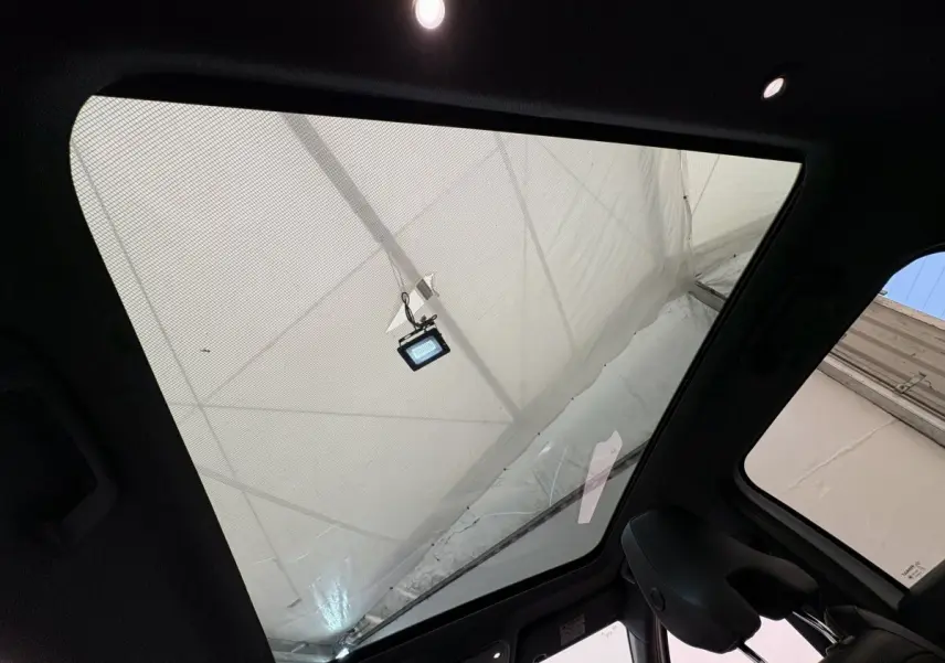 Toit panoramique en verre vu de l'intérieur côté arrière droit du Renault Austral blanc hybride 2025