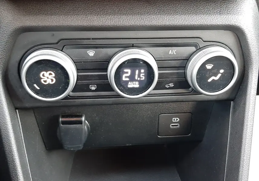 Gros plan sur la commande de climatisation automatique du Dacia Jogger 2025, avec affichage digital à 21,5°C.