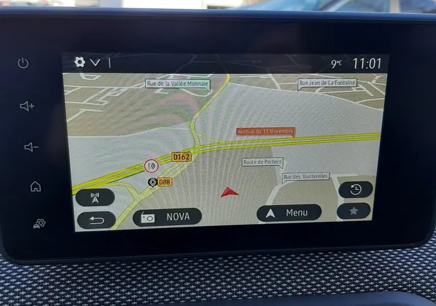 Écran tactile central affichant la navigation GPS dans un Dacia Jogger, intérieur avec tableau de bord texturé gris.