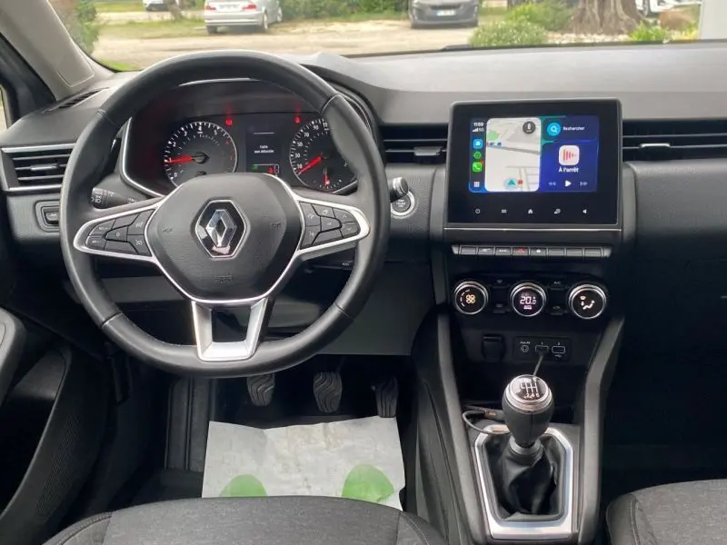 Vue intérieure frontale du tableau de bord gris platine de la Renault Clio V TCE 90 Zen avec écran tactile et boîte manuelle.