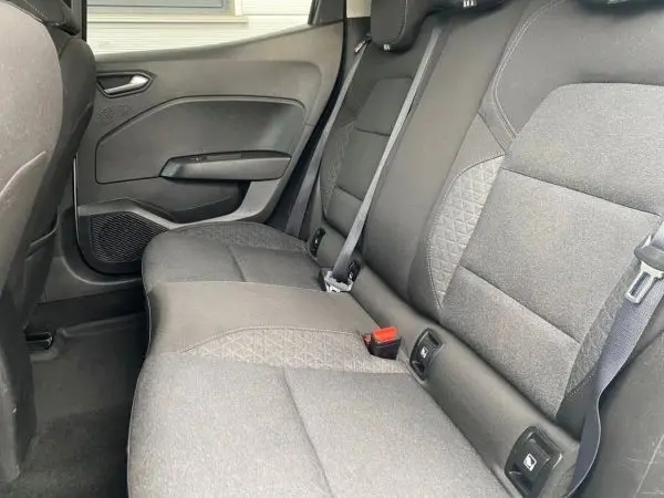 Vue intérieure du siège arrière droit de la Renault Clio V gris platine, montrant les ceintures et les finitions tissu.