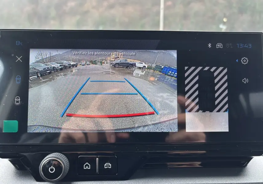 Écran tactile du Peugeot Rifter BlueHDi 130 montrant la caméra de recul avec guidage coloré en extérieur.