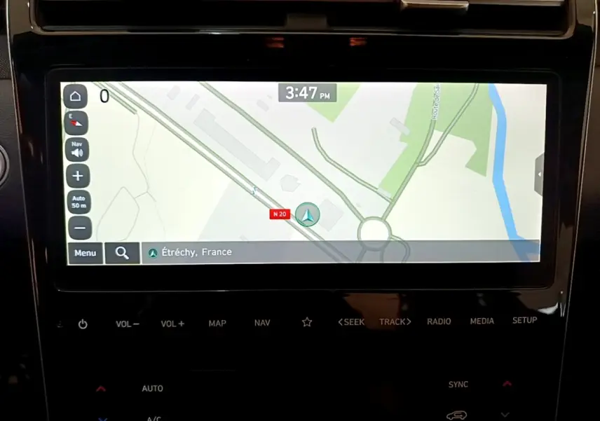 Écran tactile central affichant la navigation 3D dans un Hyundai Tucson gris foncé, vue intérieure rapprochée.
