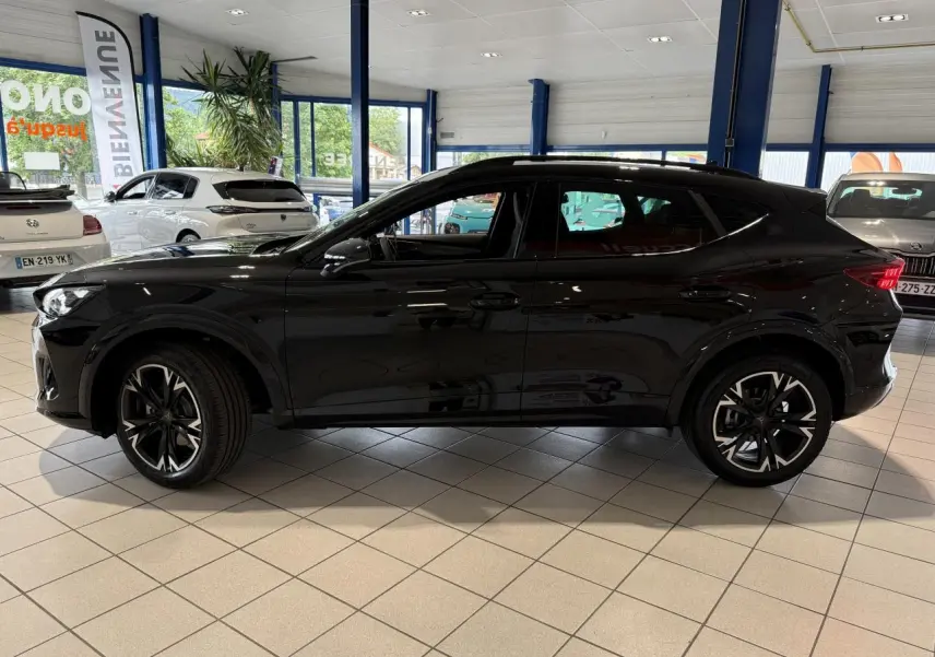 Vue de profil côté gauche d'une CUPRA Formentor 2025 noire Night avec jantes alliage 18'' en showroom.