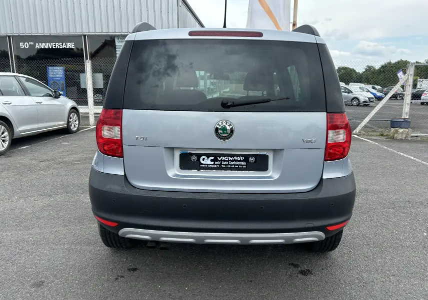 Vue arrière d'un Skoda Yeti gris 2012 avec logo central et feux rouges sur pare-chocs noir.
