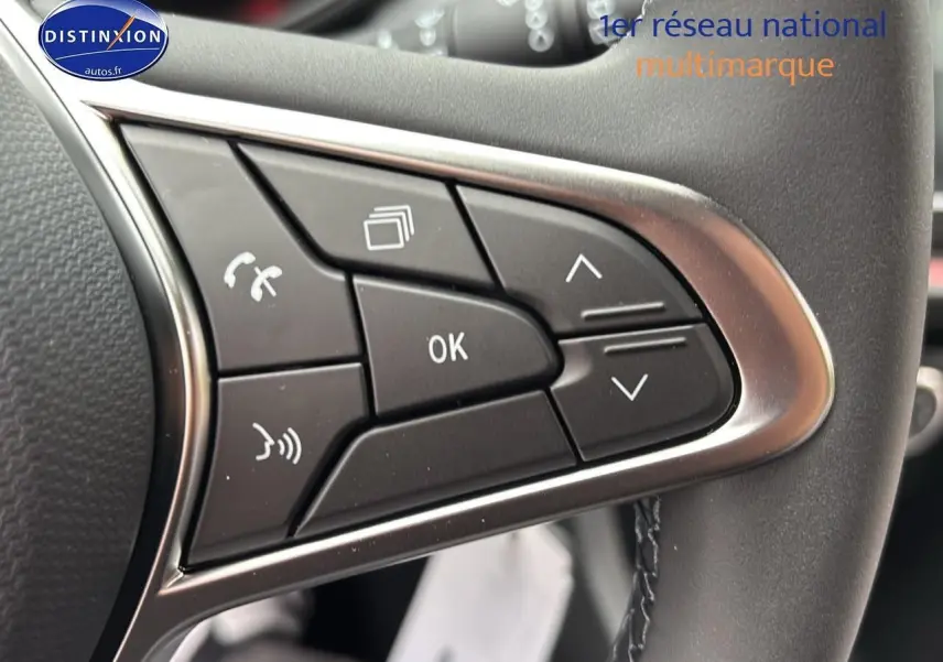 Gros plan sur les commandes multifonctions du volant cuir d'une Renault Clio V noire étoilé, avec boutons de navigation et appel.