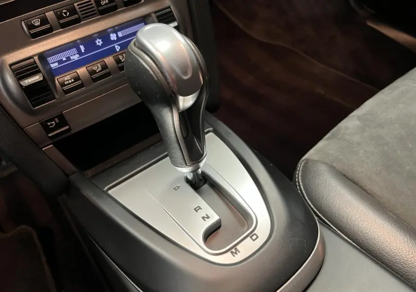 Le levier de vitesse automatique argenté et noir de la Porsche Cayman 2.7i 2008 vu de près dans l'habitacle.