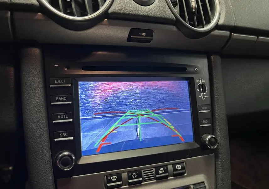 Écran central du tableau de bord d'une Porsche Cayman 2008 affichant la caméra de recul en fonctionnement.