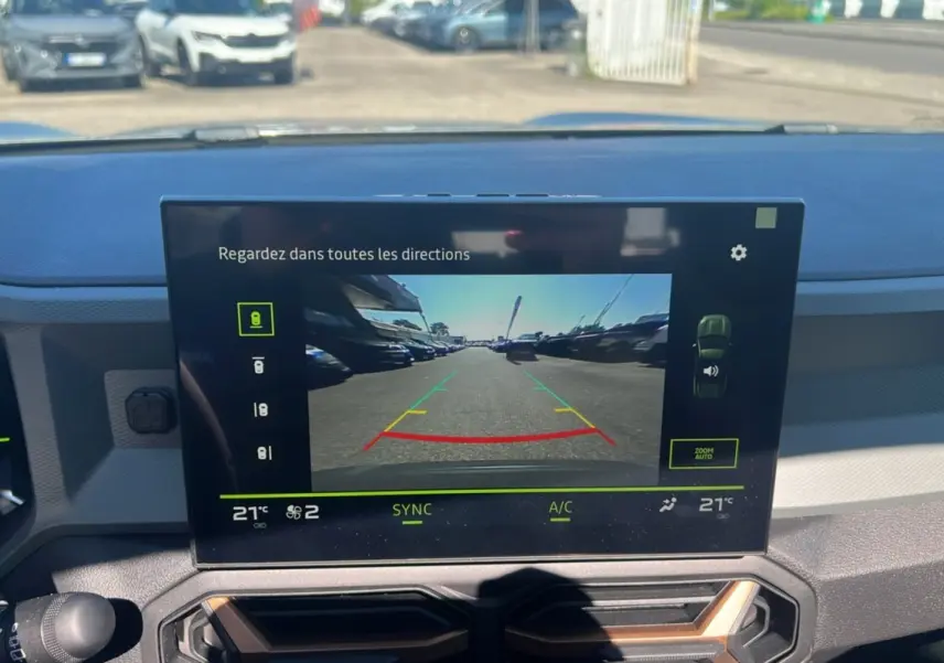 Écran central du Dacia Bigster Hybrid 155 Extreme Plus 2025 montrant la caméra de recul en extérieur lumineux.